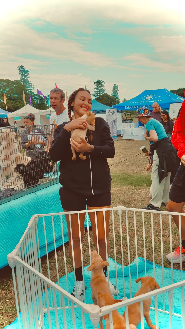A visitor cuddles a puppy at the rescue fundraising event